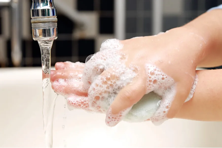 Child washing hands with soap