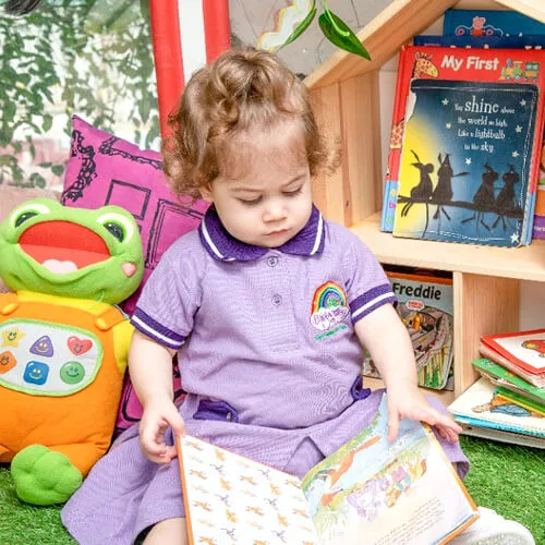 Toddler in nursery uniform playing in the classroom