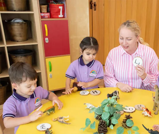 Teacher and two children doing a table activity at Rainbow Valley Nursery