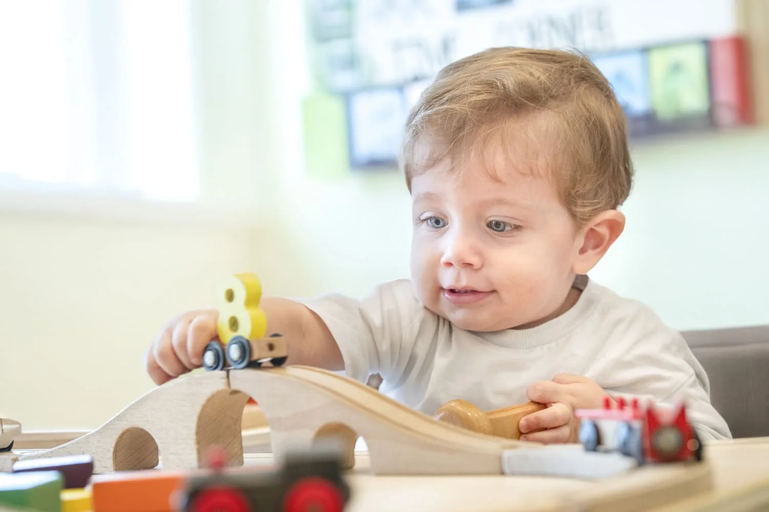 Toddler playing with a wooden train set